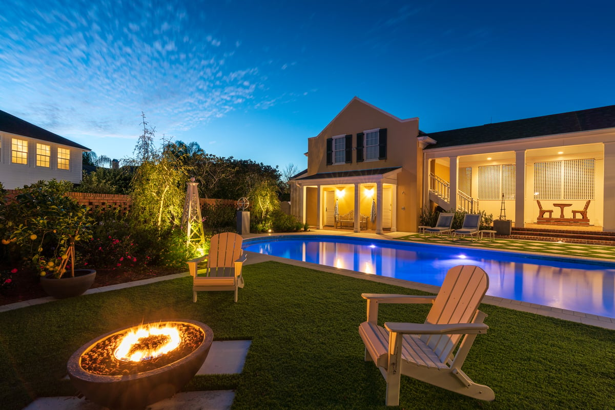 backyard with firepit and pool with landscape lighting