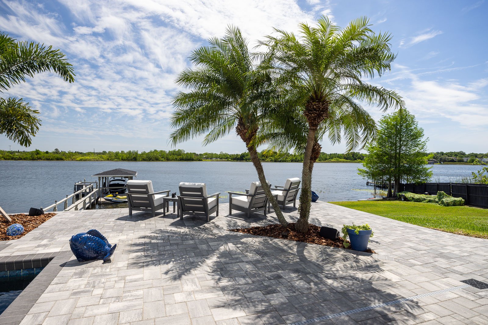 hardscape pavers pool decking with palm trees outdoor furniture waterfront view 13