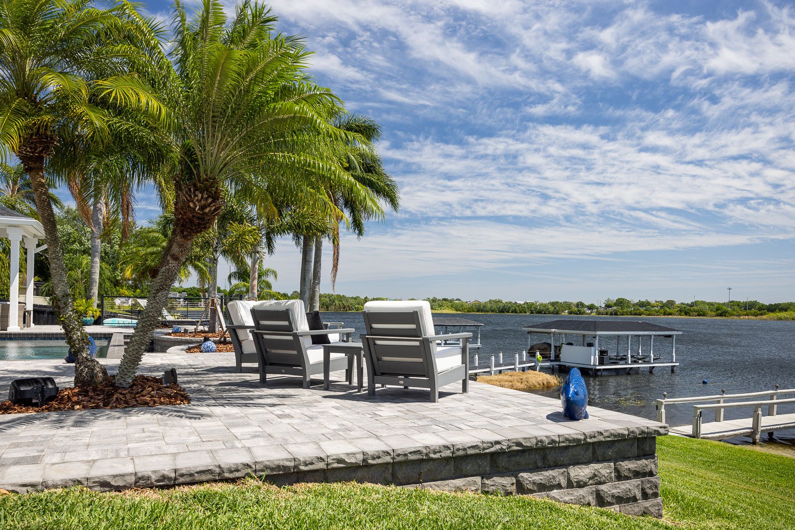 hardscape pavers pool decking with palm trees outdoor furniture waterfront view 20