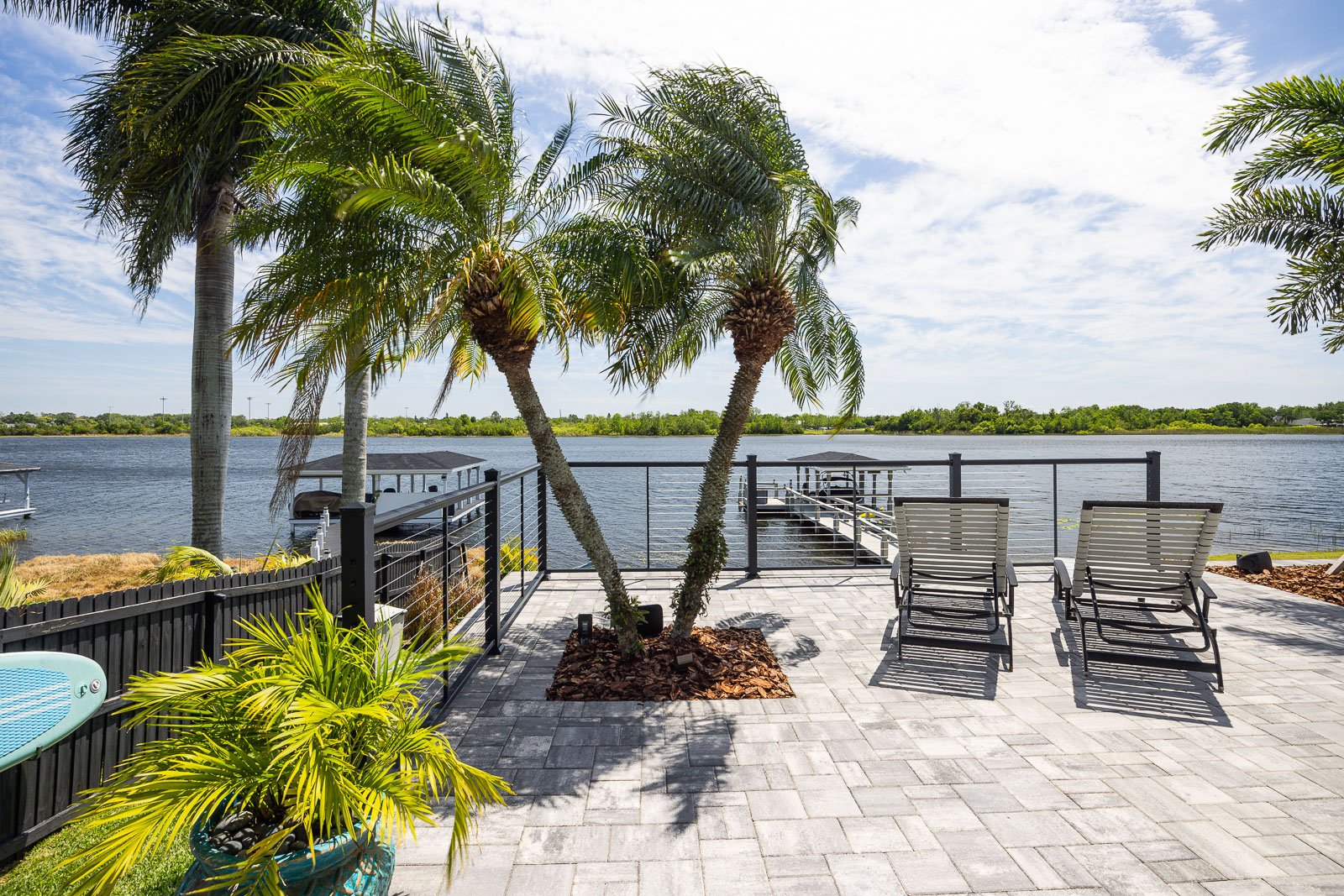hardscape pavers pool decking with palm trees outdoor furniture waterfront view 5