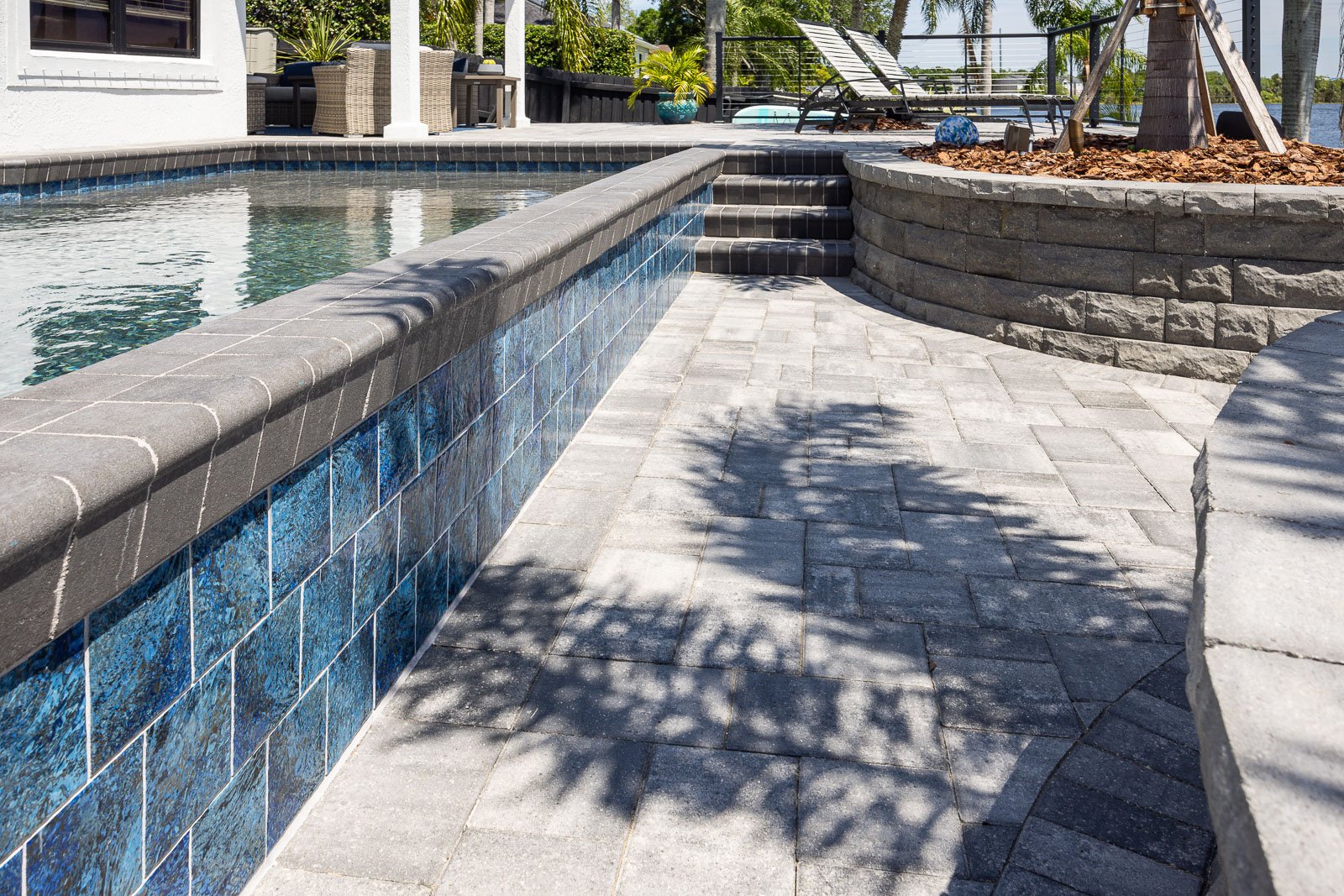pool with hardscape paver pool decking and raised planters 2
