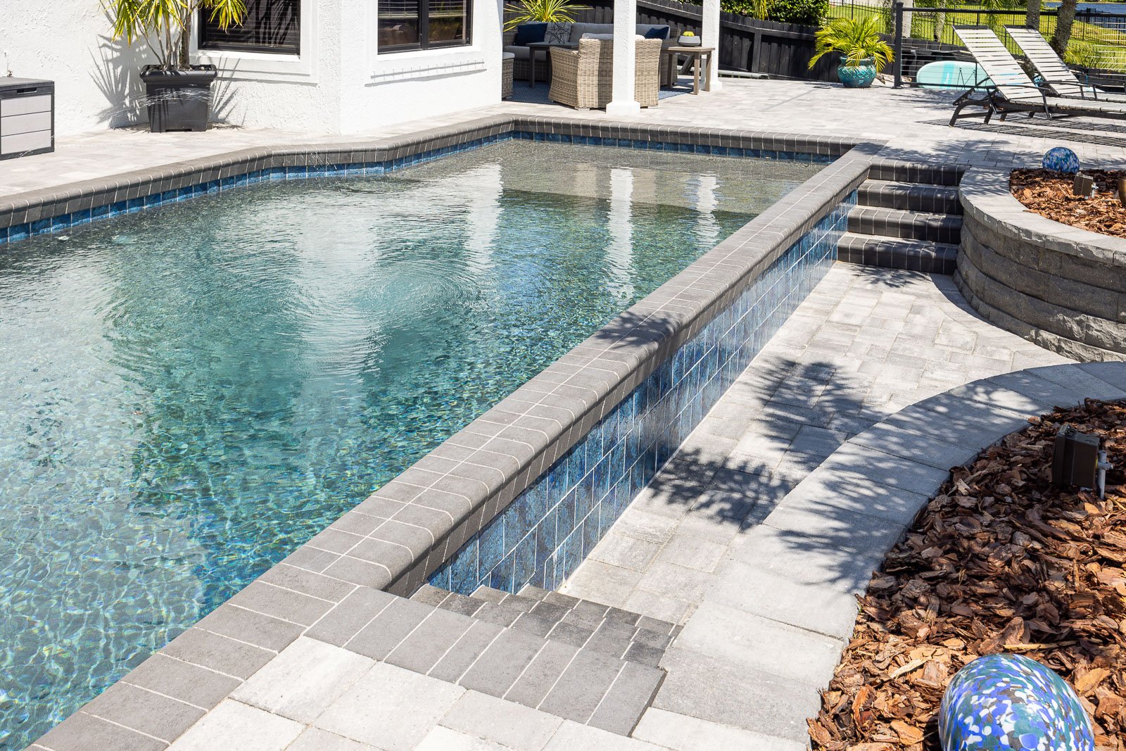 pool with hardscape paver pool decking and raised planters