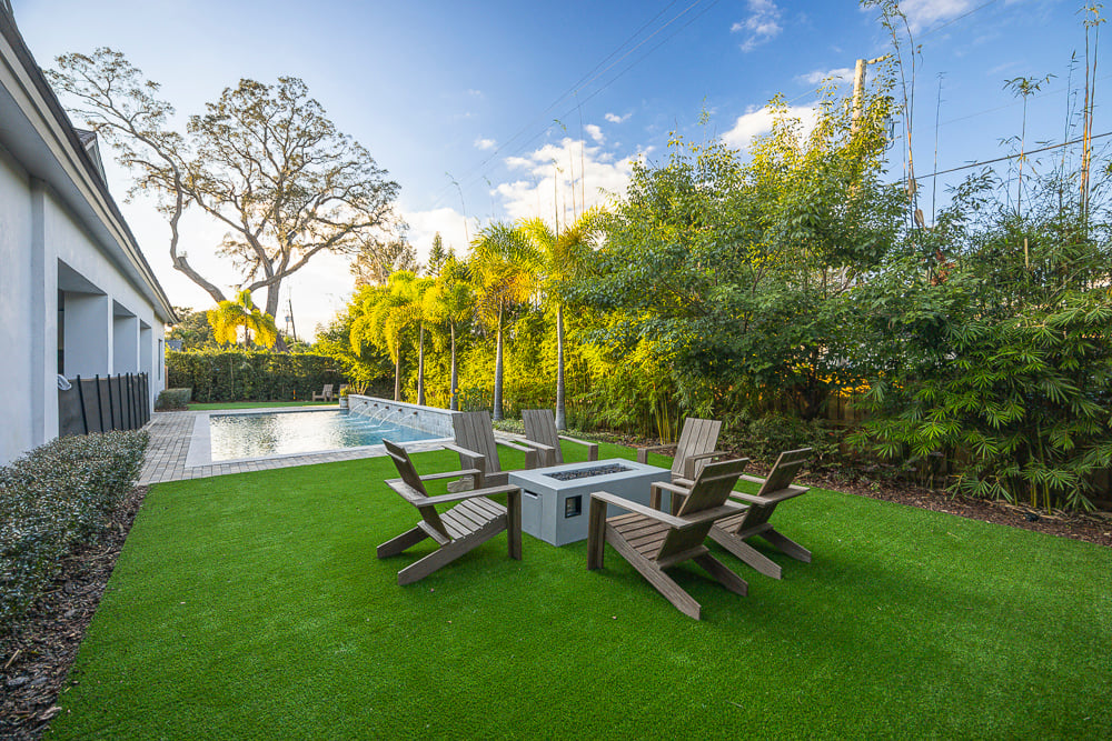 backyard with artificial turf, pool and planting beds