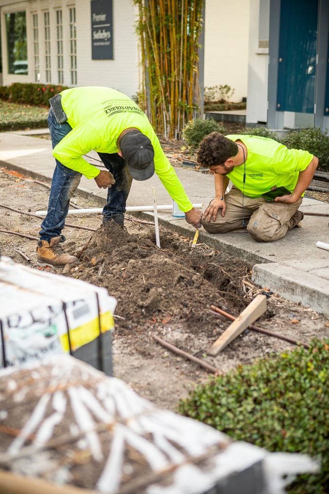 irrigation experts install irrigation under walkway