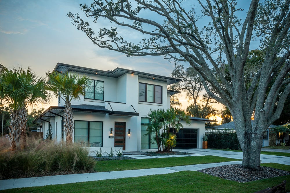 nice front yard landscaping at dusk with large shade tree palm trees and lawn in central florida