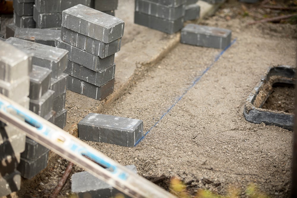 concrete pavers cut saw level string and sand during a paver sidewalk installation tools