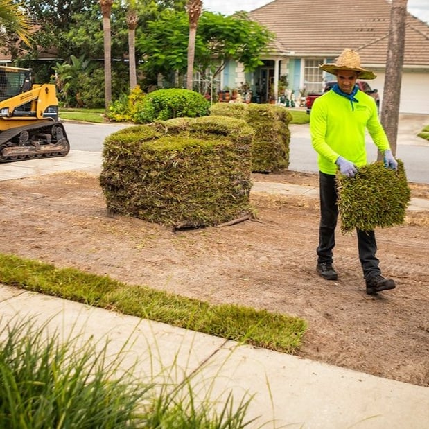 landscape technician placing sod on new lawn