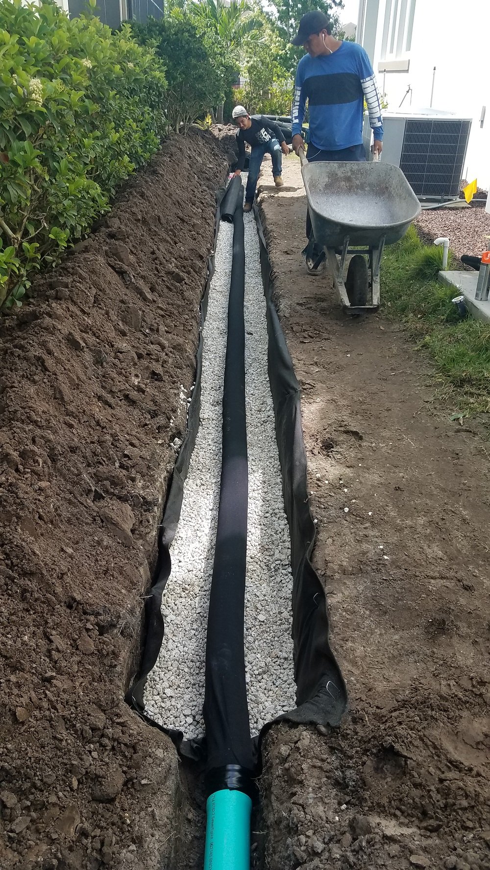 landscape professionals install french drain to prevent yard flooding