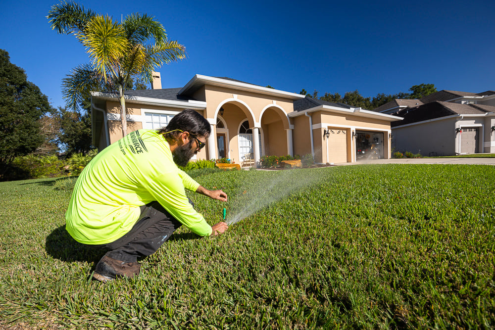 irrigation technician inspecting sprinkler head