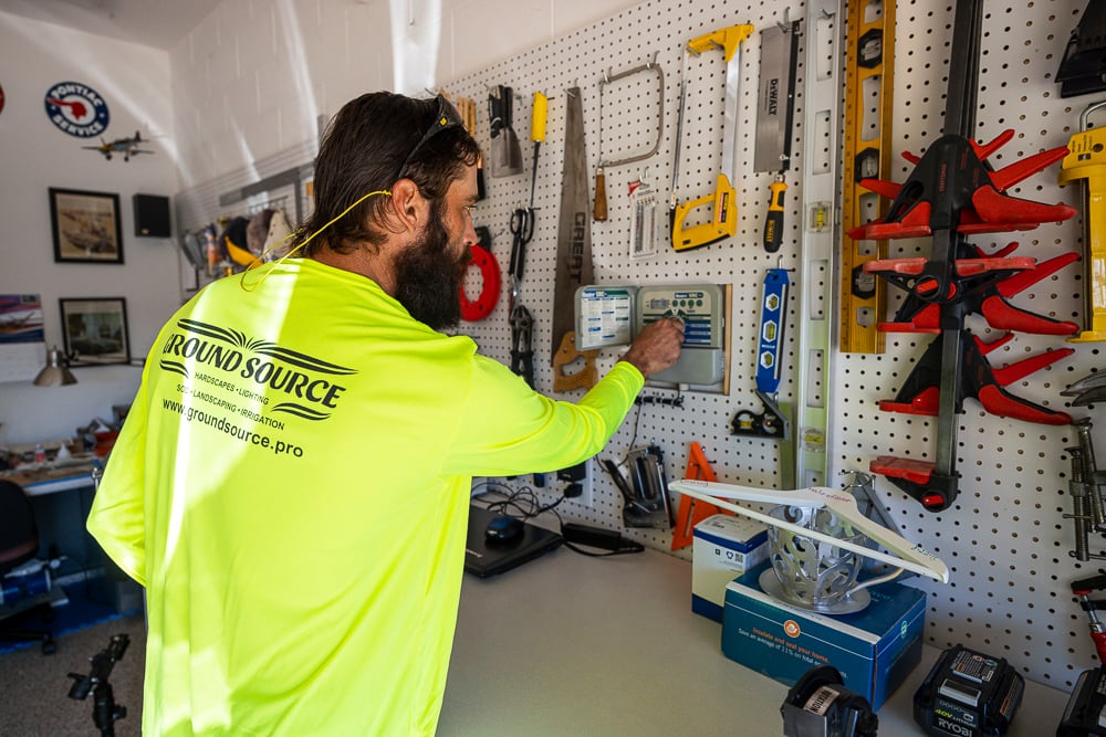 Irrigation Technician sets sprinkler system timer