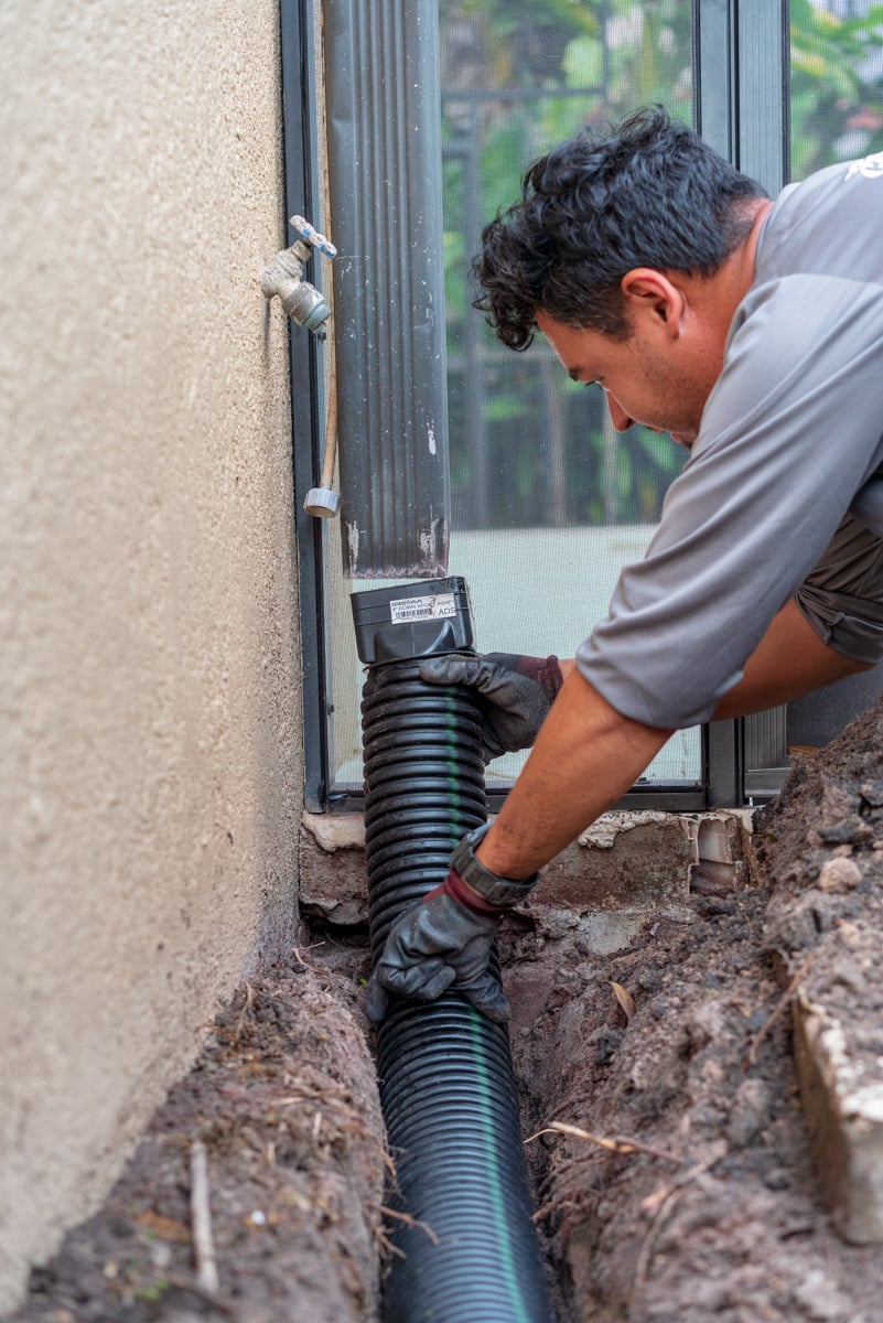 Adjusting downspouts to install pavers