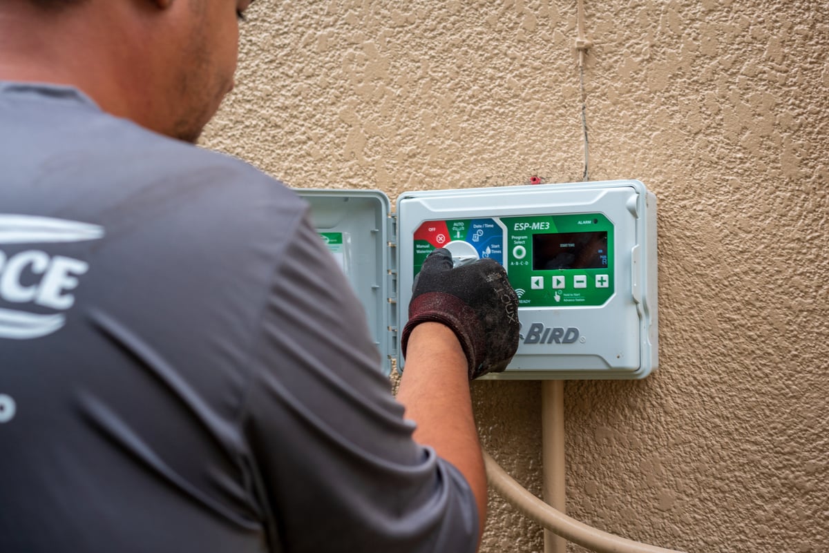 irrigation crew inspects smart irrigation controller