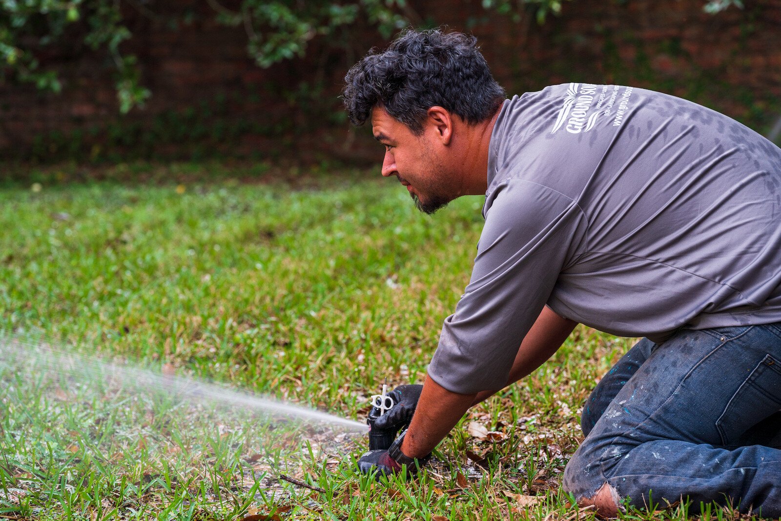 Landscape crew making an irrigation system adjustment