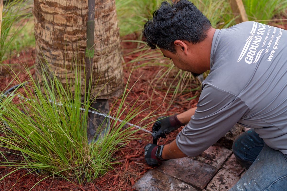 irrigation technician repairs sprinkler head