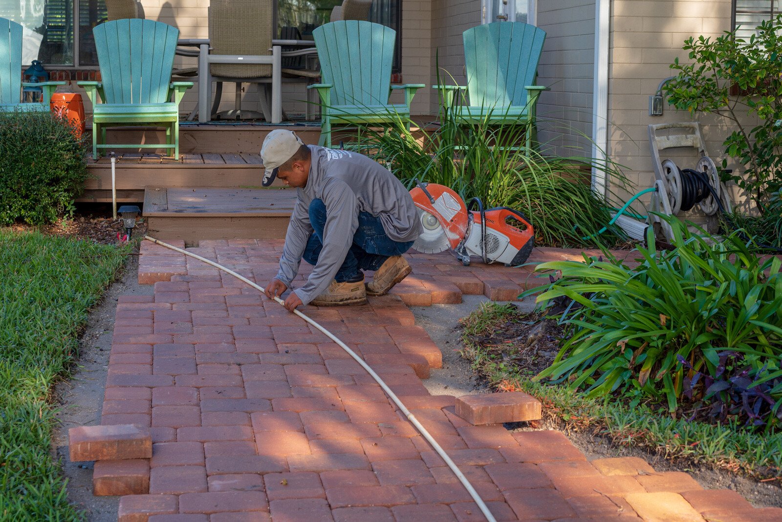 hardscape installation technician installing a paver sidewalk