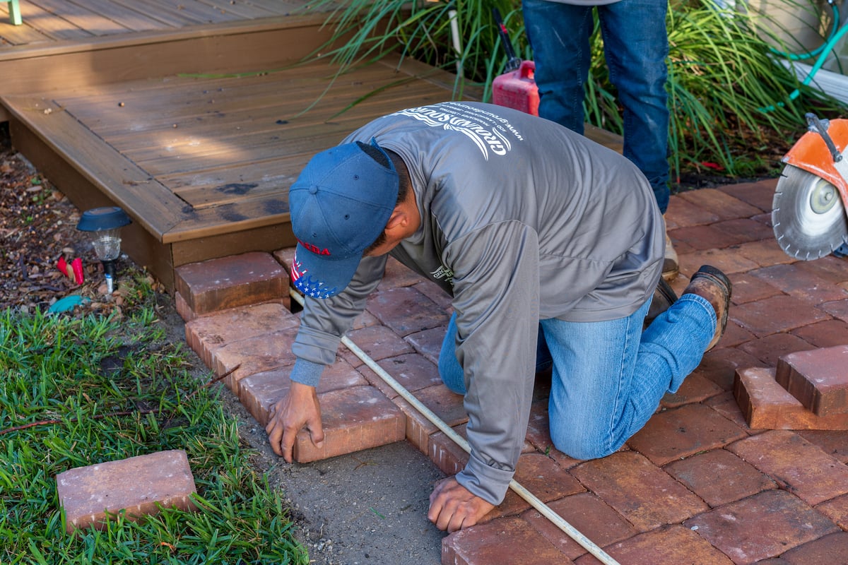 landscape installation team install brick pavers