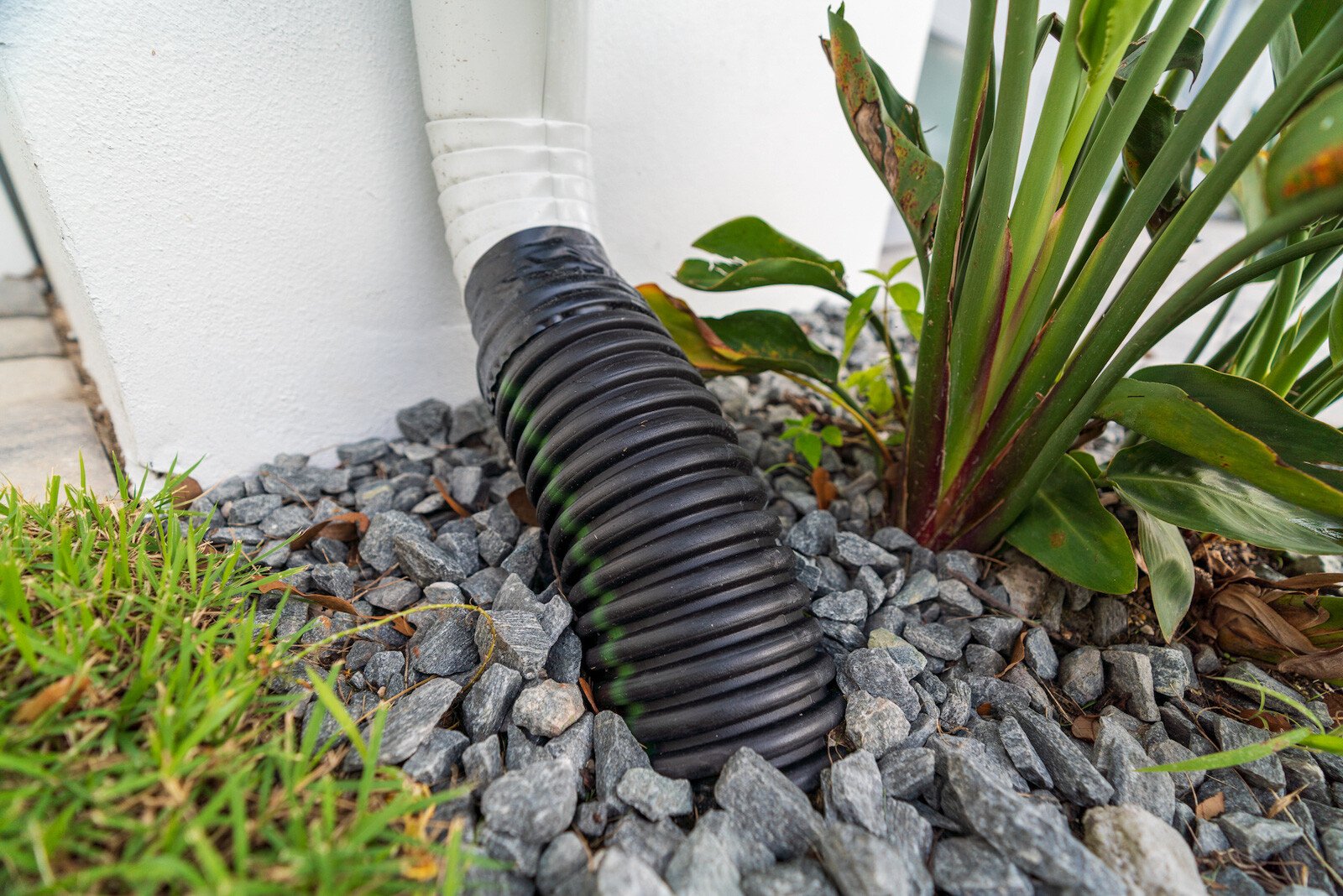 drainage downspout surrounded by stone