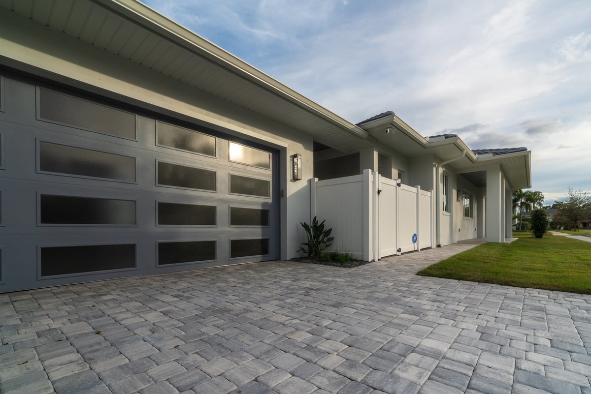 paver driveway in front of home with green grass