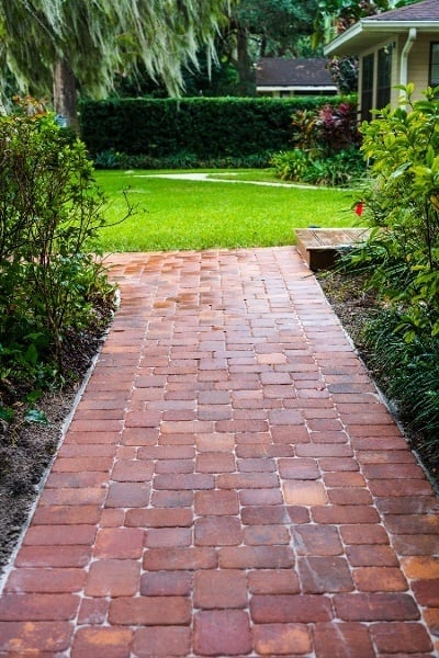paver walkway with landscape beds and lawn