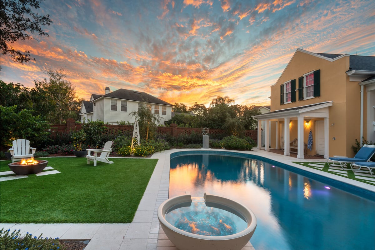 artificial grass around pool area with firepit and landscaping