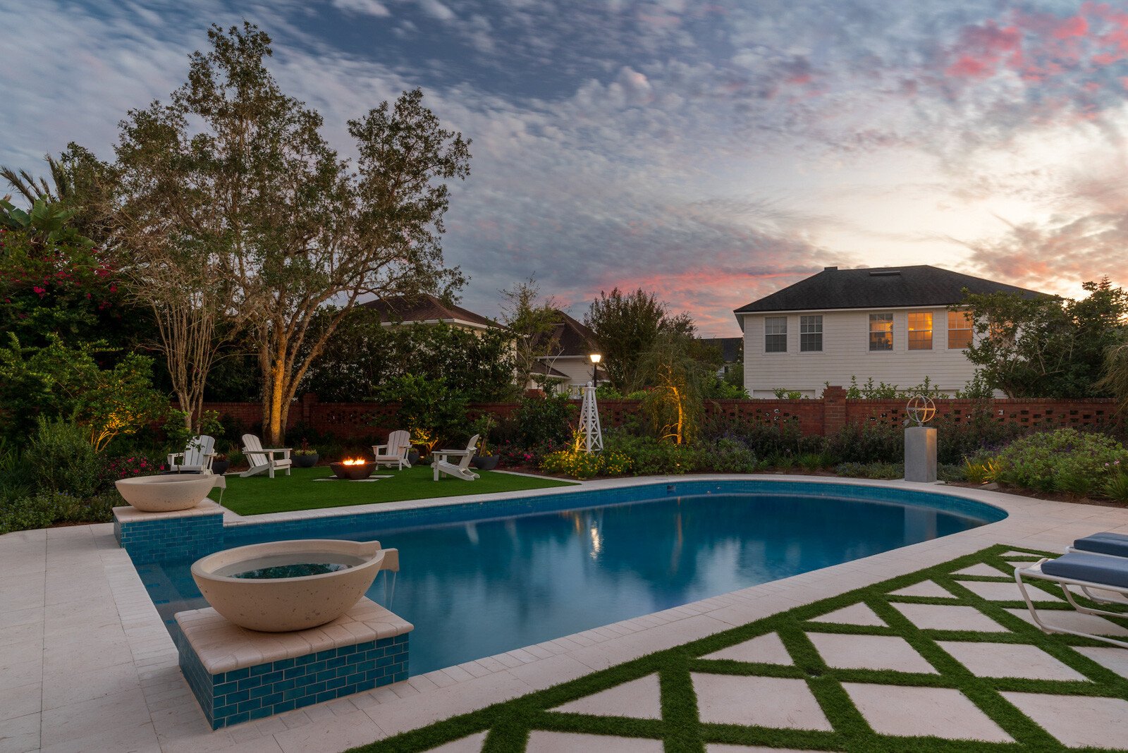 Poolside patio with white travertine and artificial turf