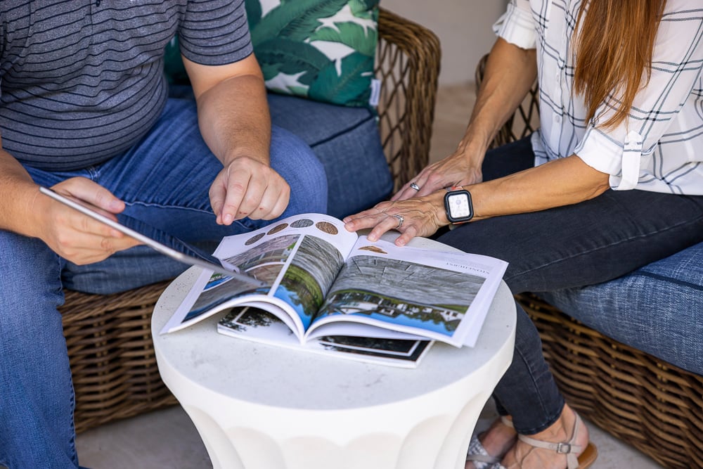 landscape designer and customer during a consultation reviewing a brochure