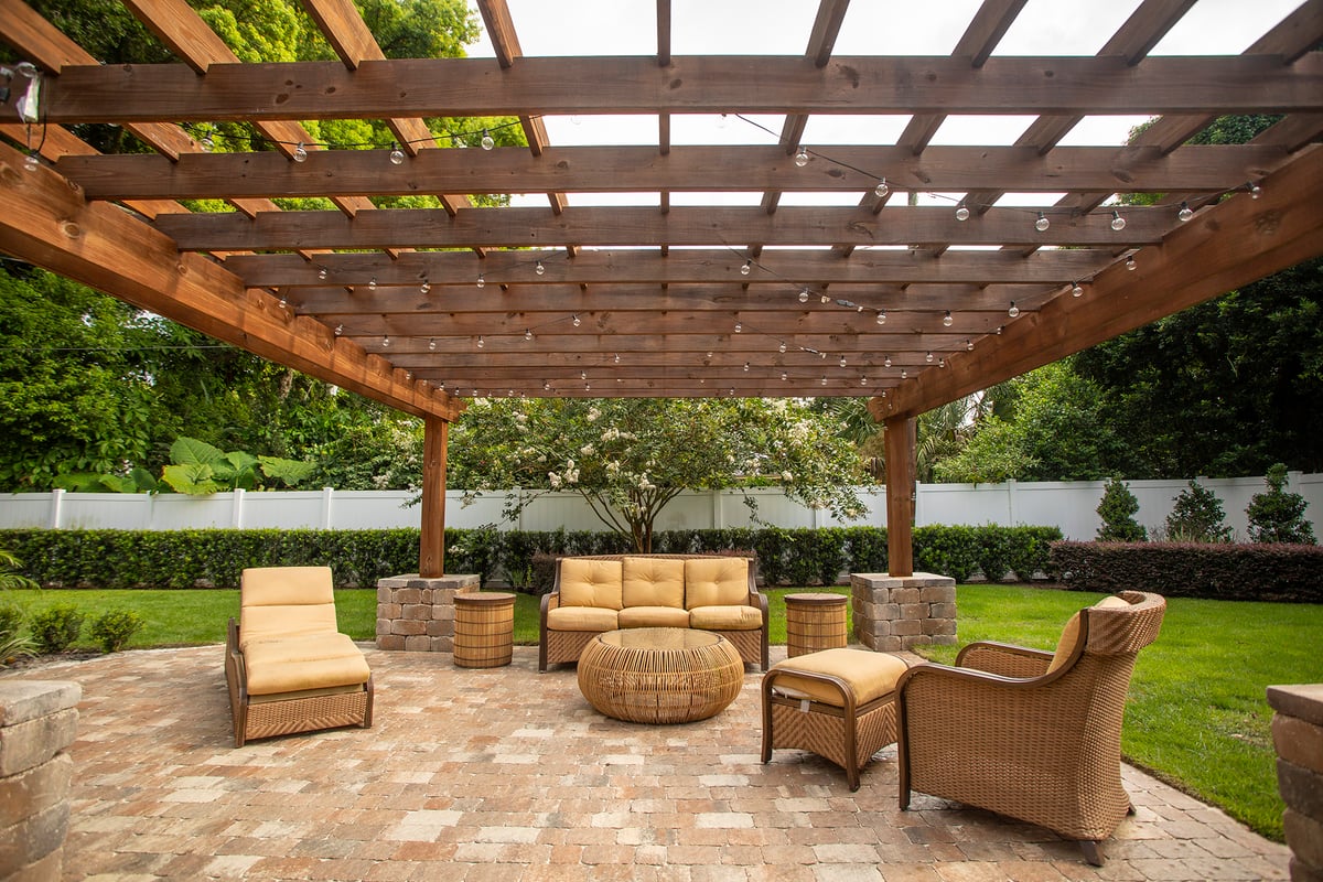 pergola with seating and healthy lawn and plantings
