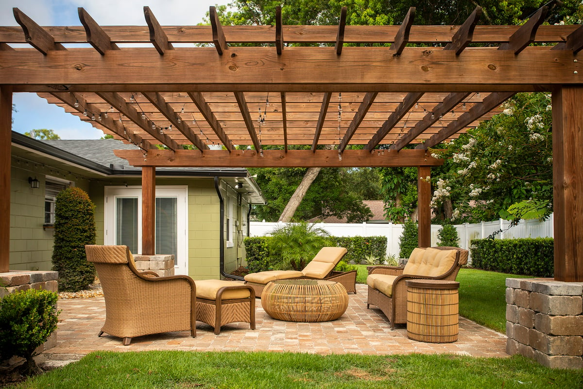 pergola with seating area underneath and surrounding plantings