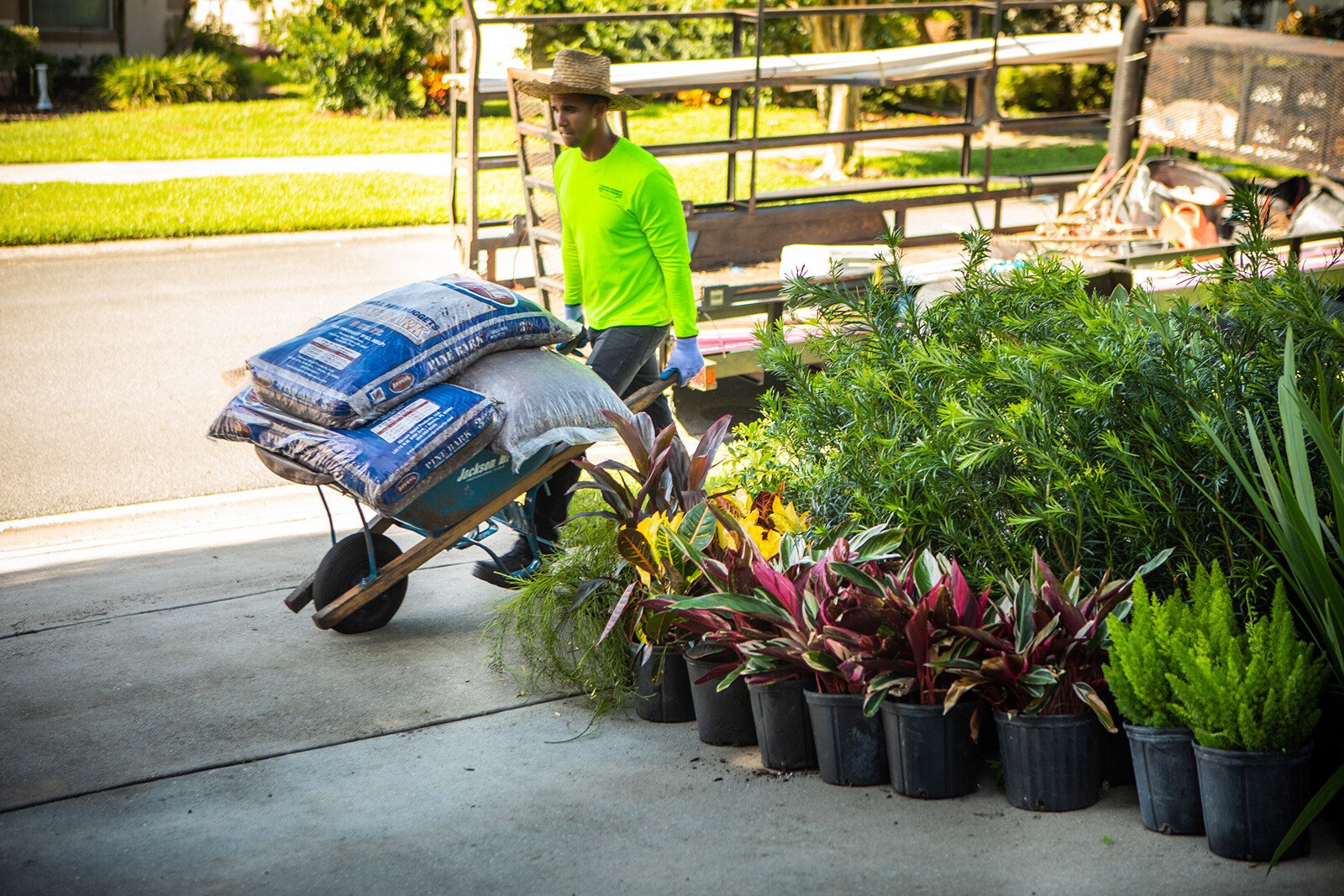landscaper loading plants and mulch with a wheelbarrow