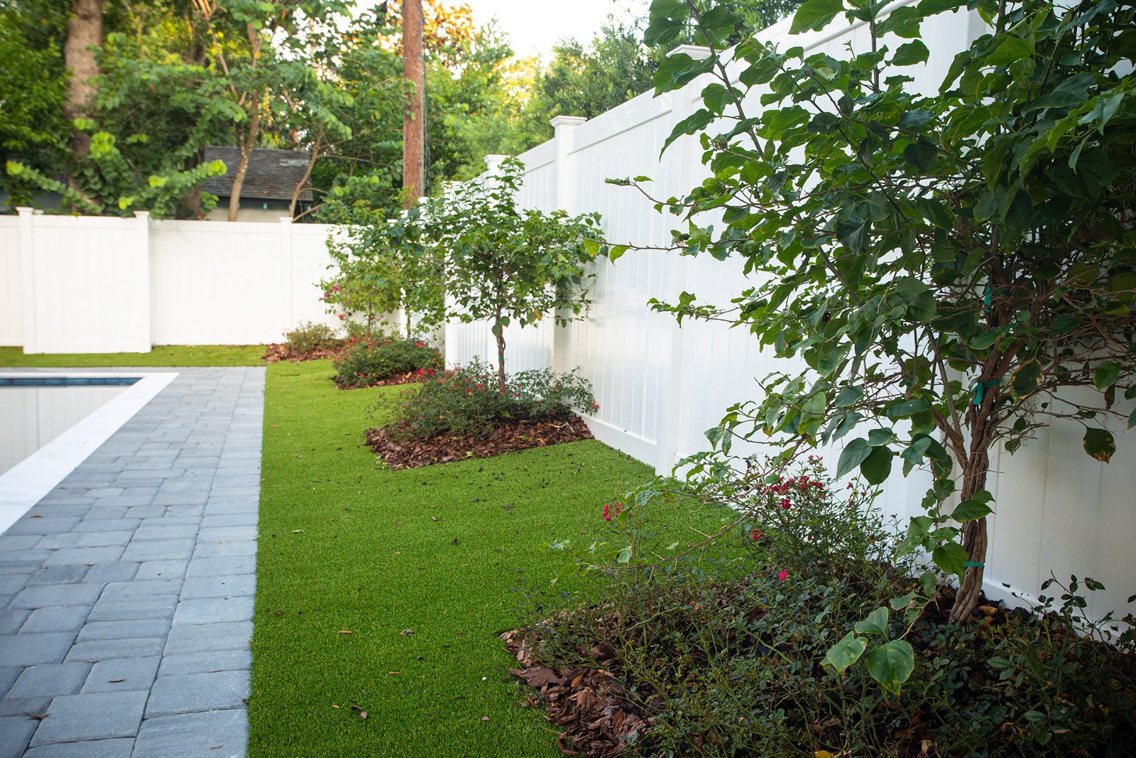 Artificial grass around pool in backyard