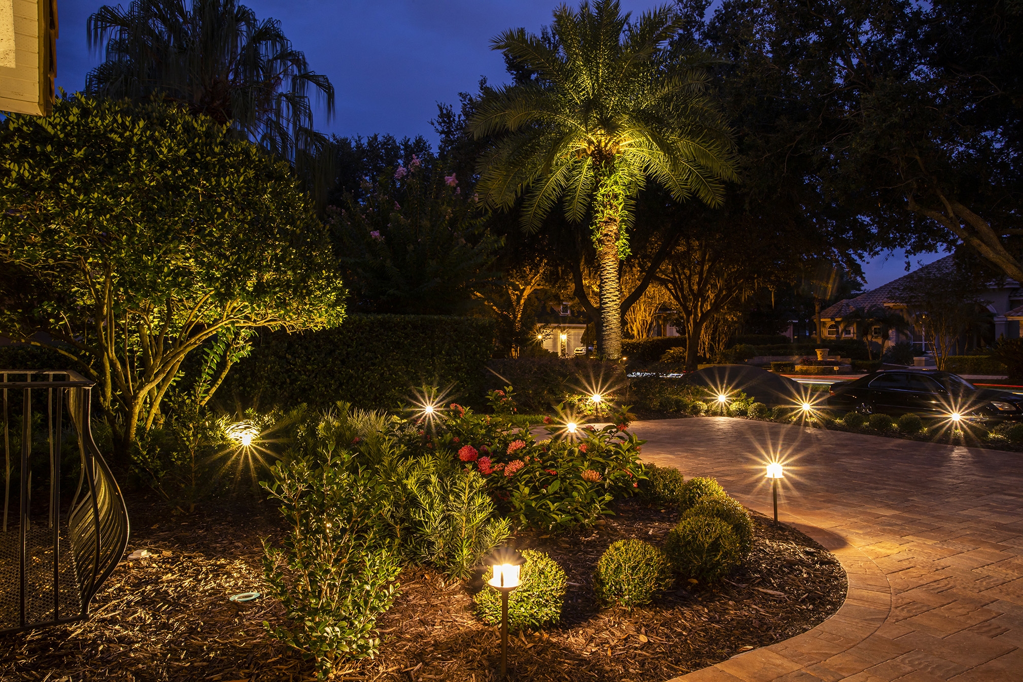 landscape lighting in backyard with patio and trees