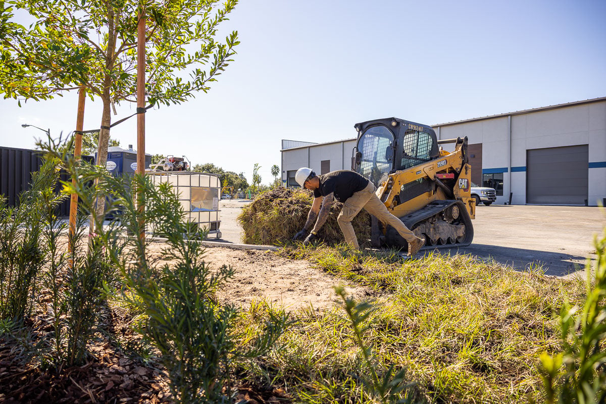 commercial landscapers installing a new green space outside a central florida warehouse