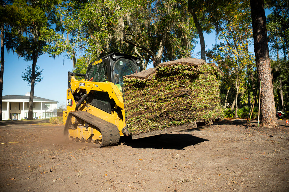 skid steer loader moving a pallet of sod on an orlando lawn