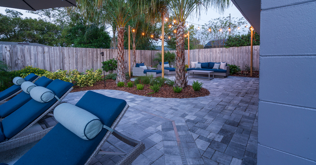 patio with string lights and palm trees