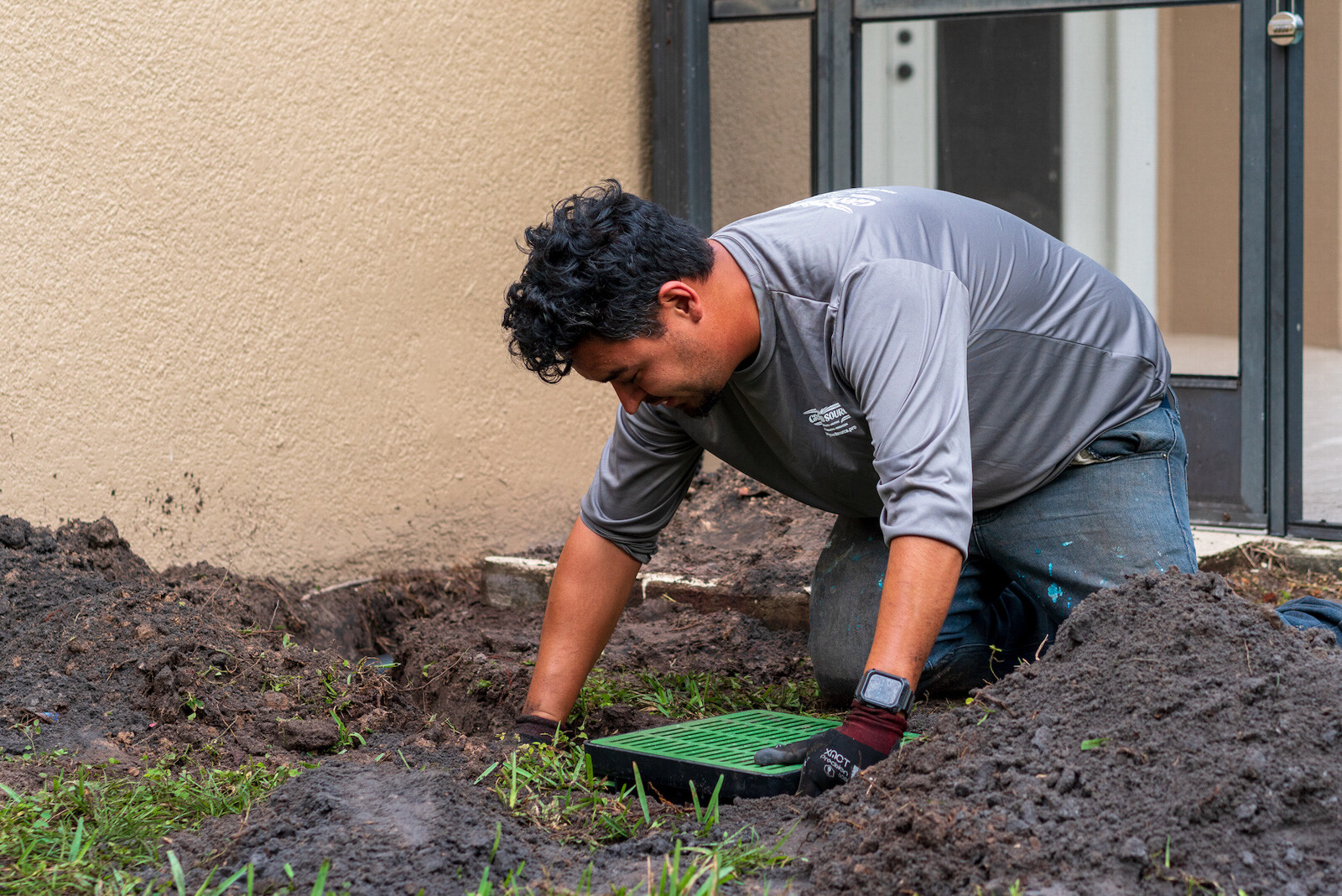 Landscape contractor installing drainage solutions for a yard