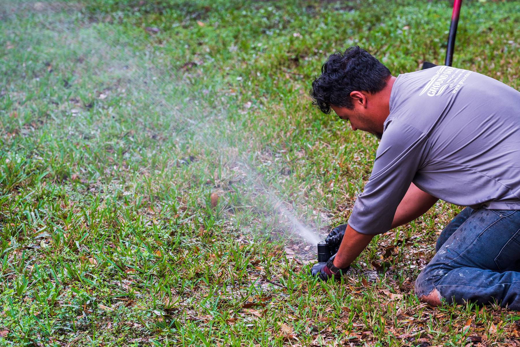 irrigation technician repairs sprinkler system