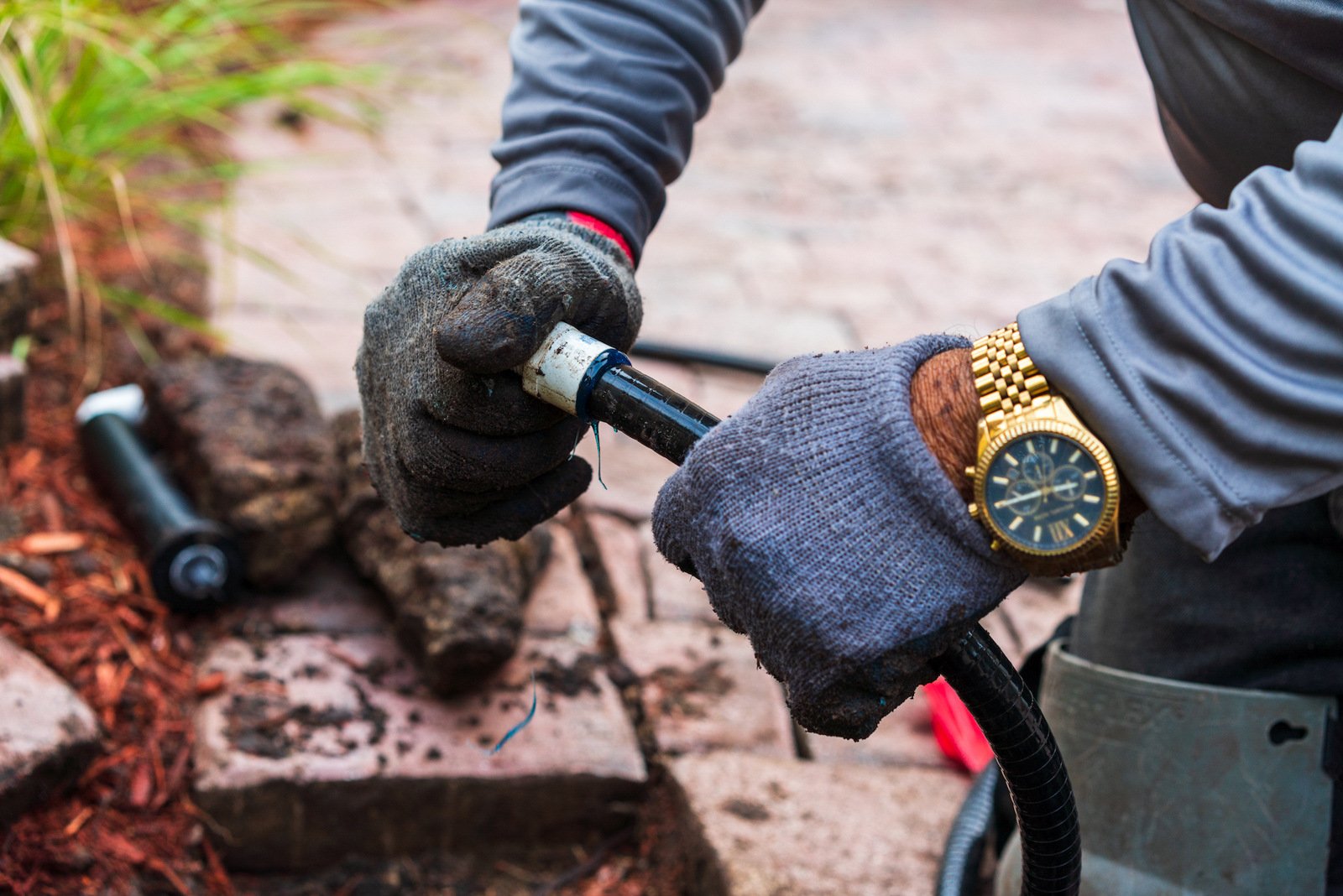 irrigation technician repairs sprinkler system line