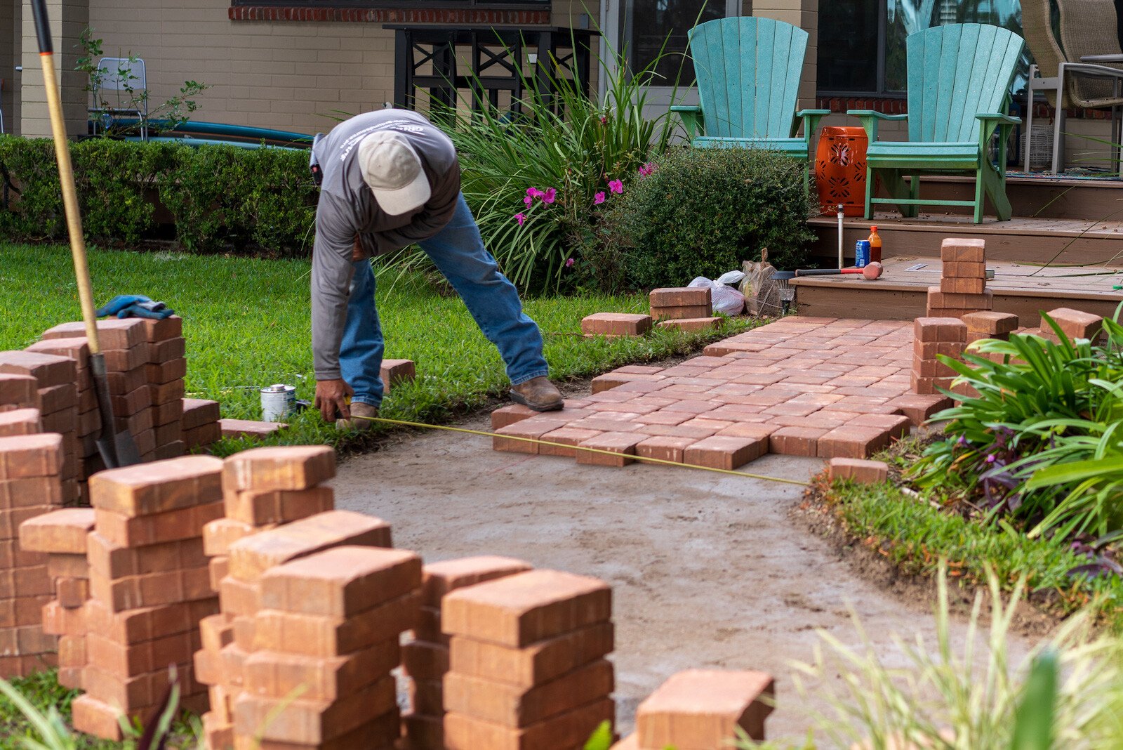 hardscape technician installing brick pavers in a florida landscape