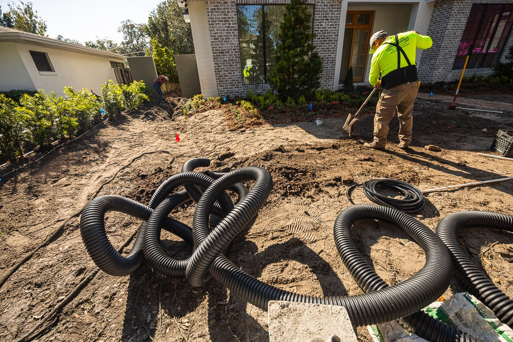 landscape installation team installing french drain in a central florida yard